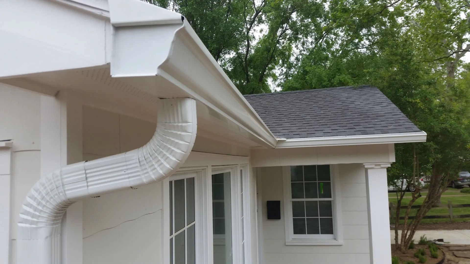 Beige house exterior with tan gutter system and windows.