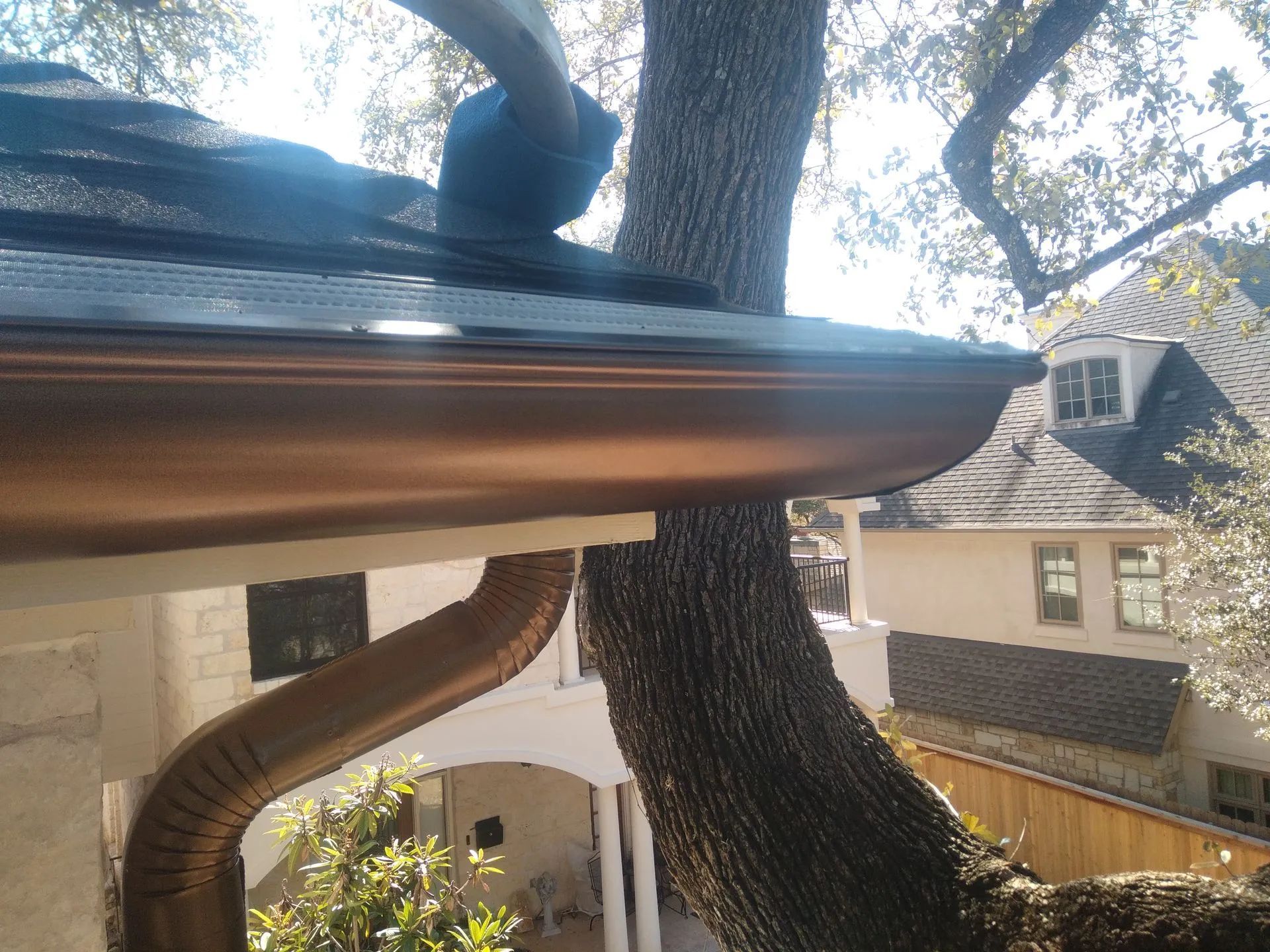 Gray metal roof with matching gutters, seen from a low angle.