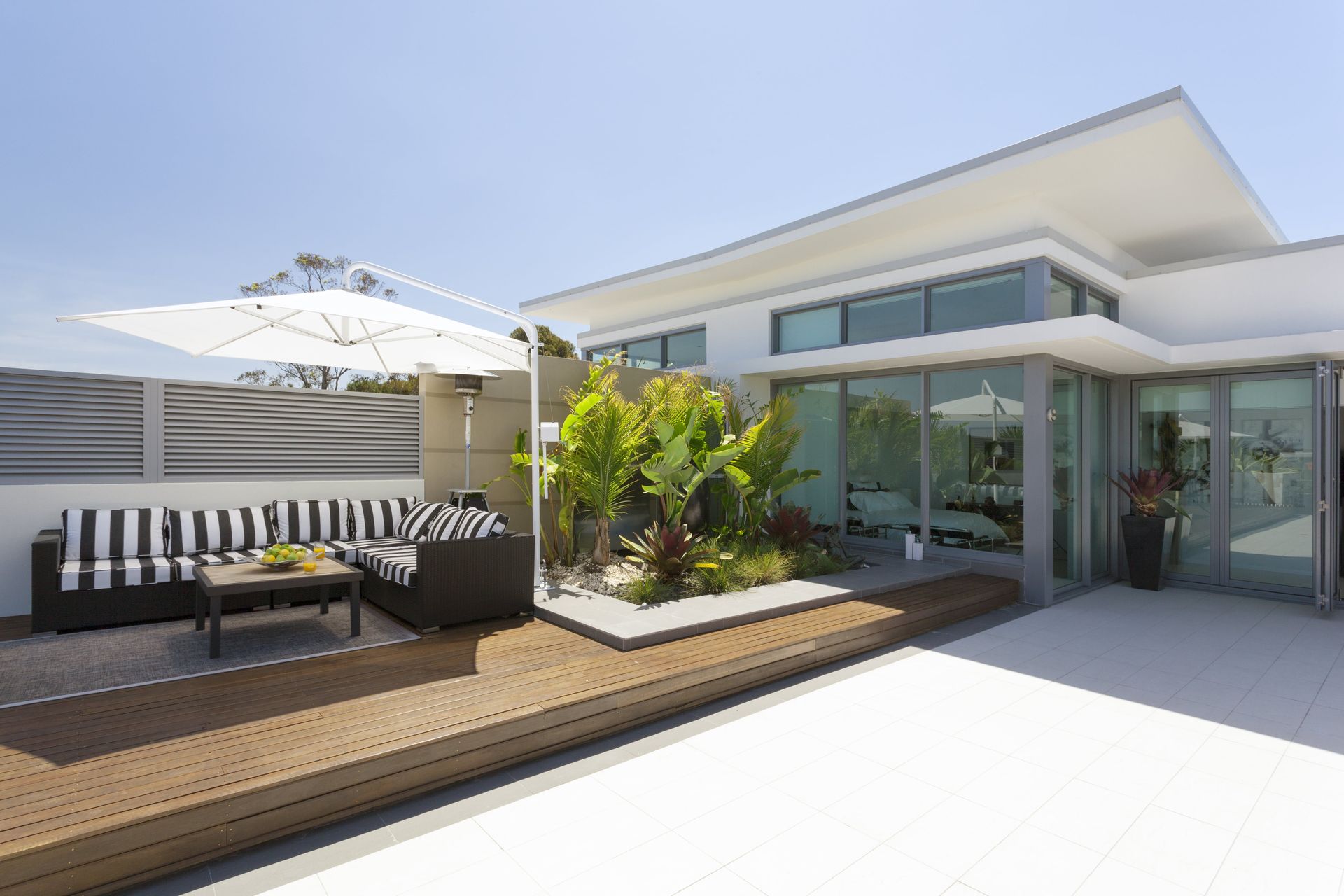 A modern house with a patio with a couch and umbrella