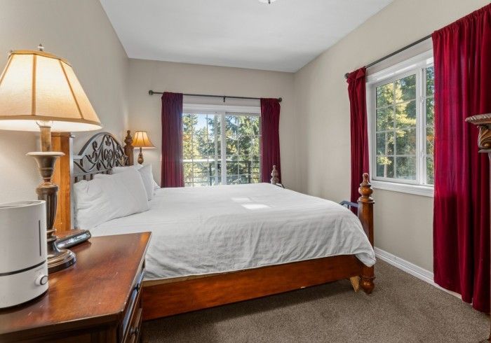 A bedroom with a king size bed and a lamp