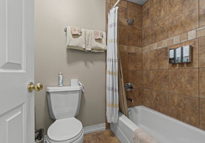 A bathroom with a toilet , tub and shower.