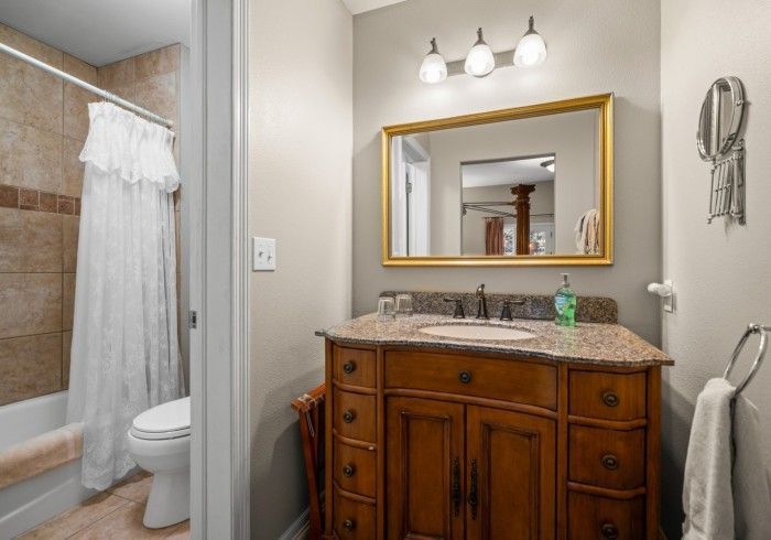 A bathroom with a sink , toilet , and mirror.