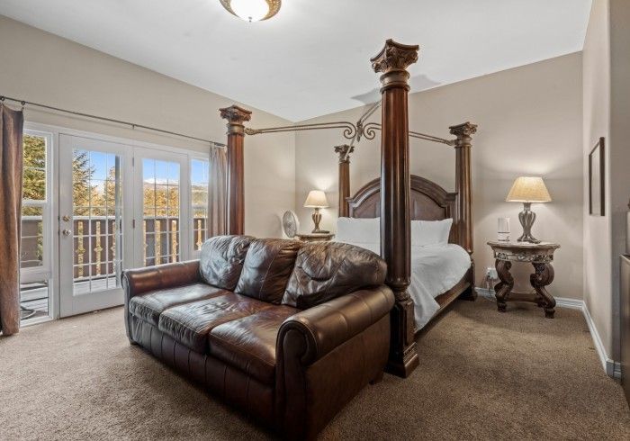 A bedroom with a four poster bed and a couch.