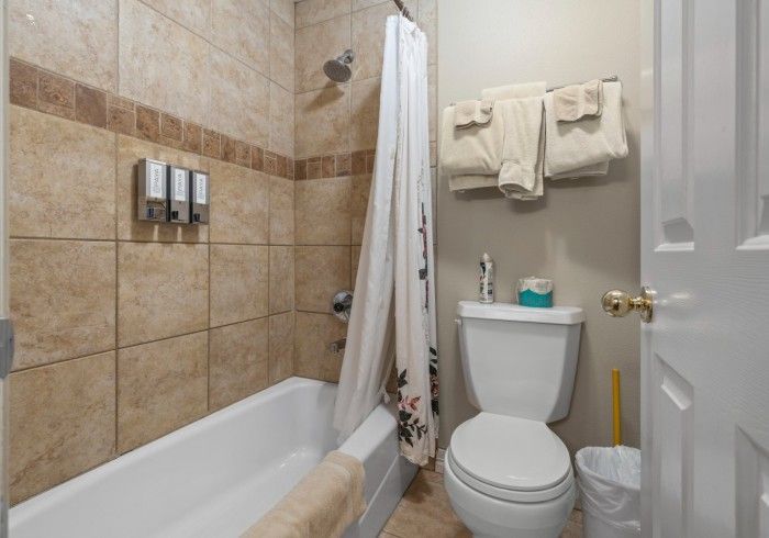 A bathroom with a toilet , tub and shower.