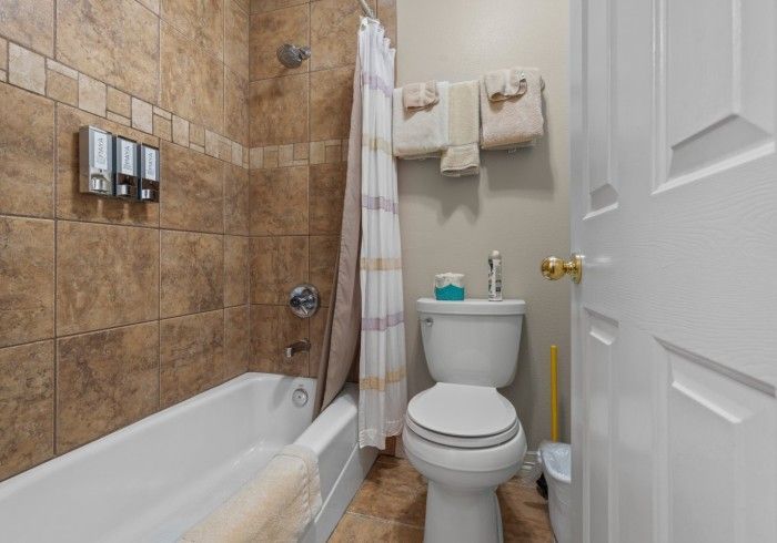 A bathroom with a toilet , bathtub and shower.