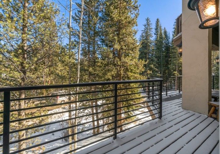 A balcony with a railing and trees in the background