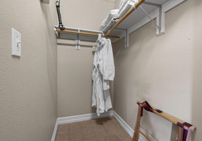 A walk in closet with a robe hanging on a rack