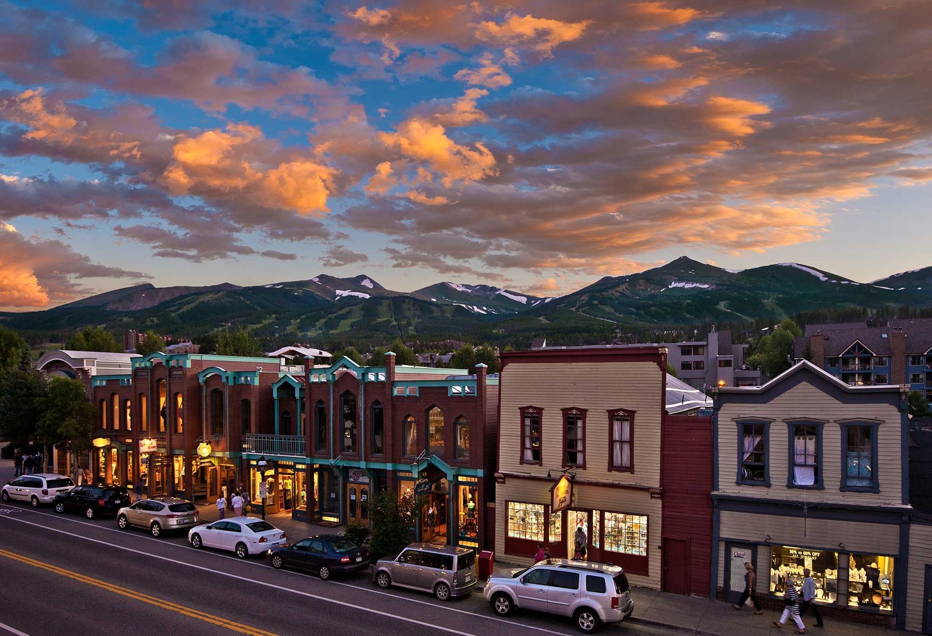 A row of buildings along a street with mountains in the background