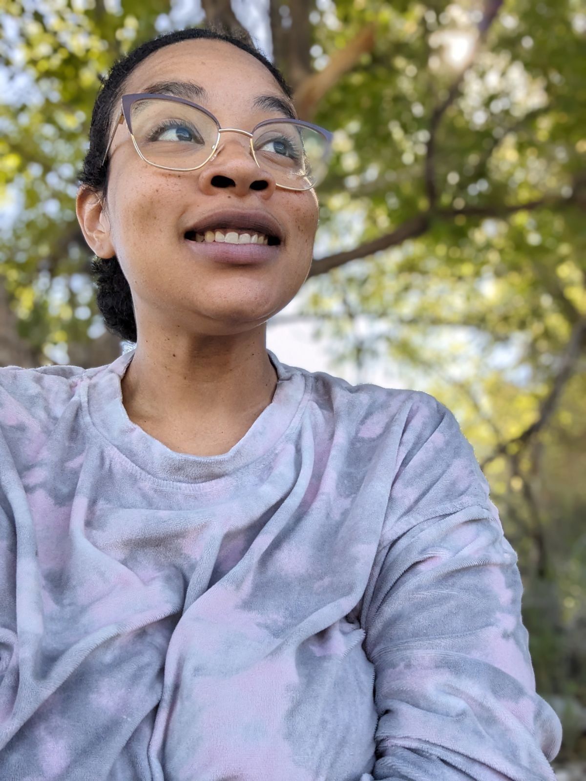 A close up of a woman wearing a necklace and a white shirt.