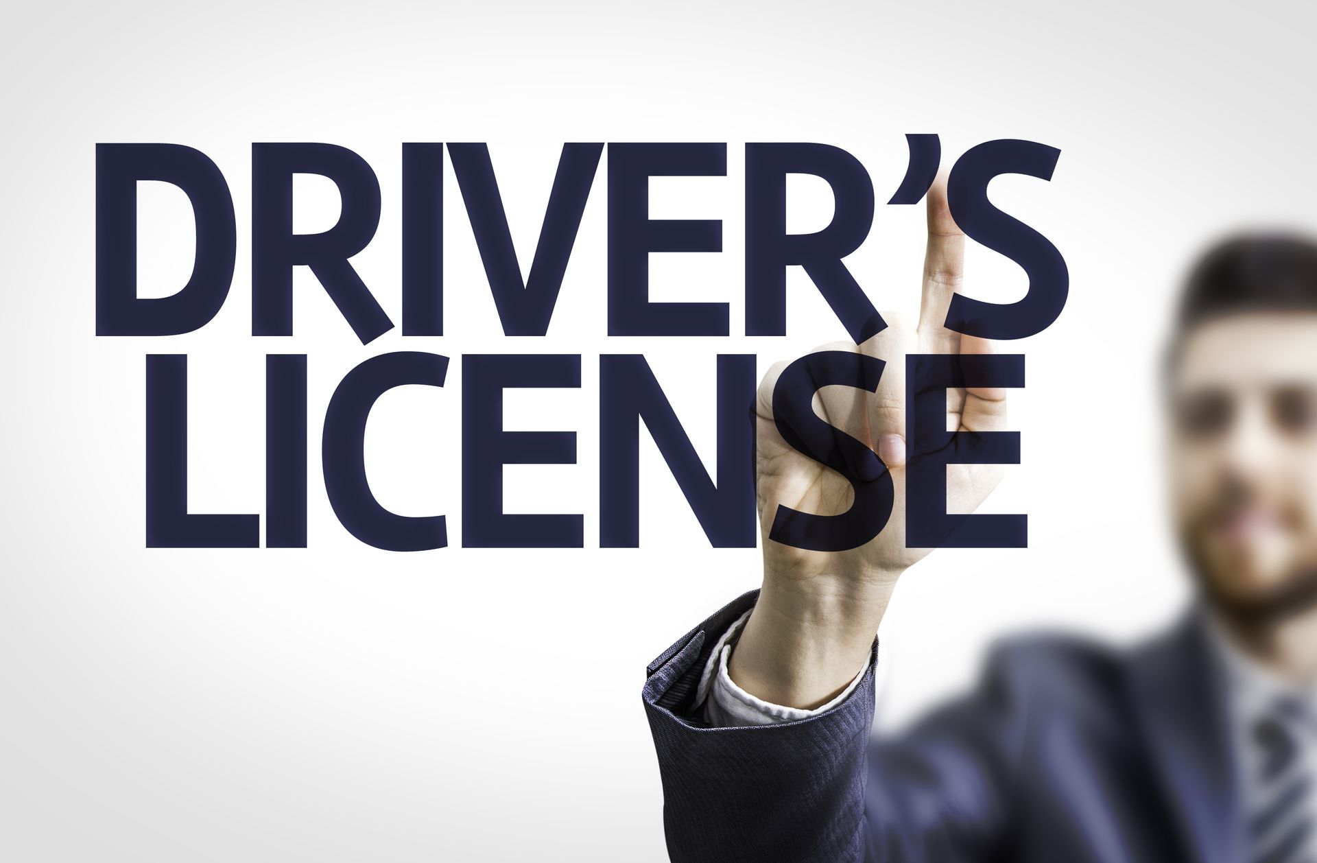 An Image of a man in a suit and tie holding his hands up and the phrase drivers license