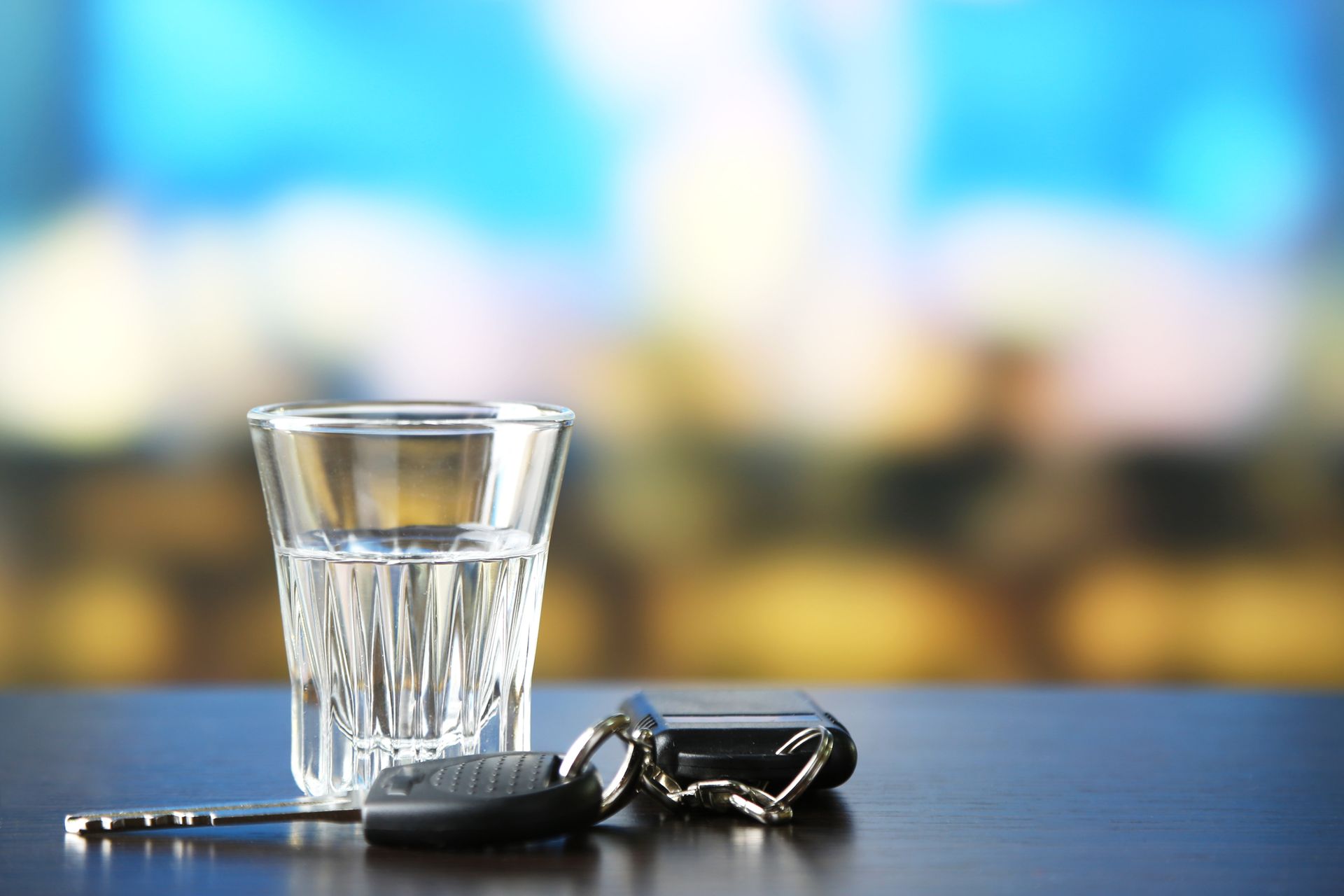 An image of a car key next to an empty glass