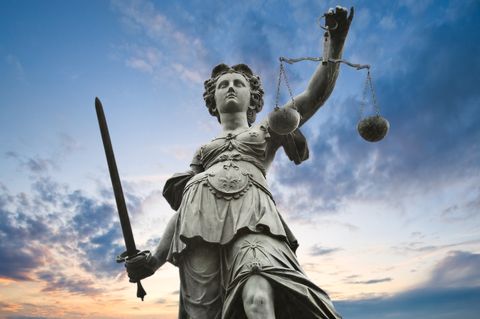 An image of Lady Justice with clouds in the background
