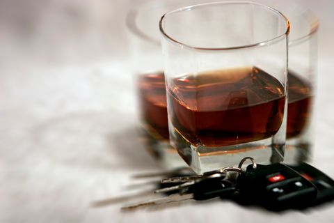An Image of a set of car keys next to a half empty glass of whisky