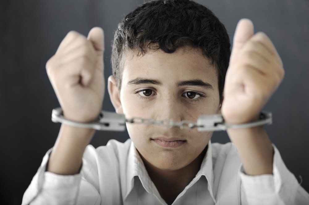 An Image of an arrested  juvenile child wearing handcuffs
