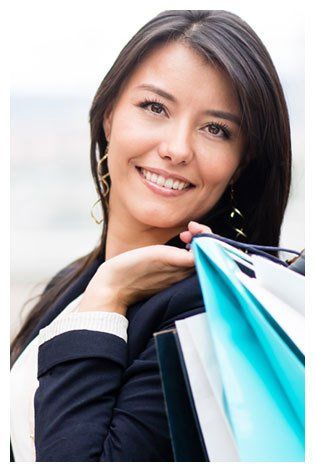 young business woman smiling while holding shopping bags