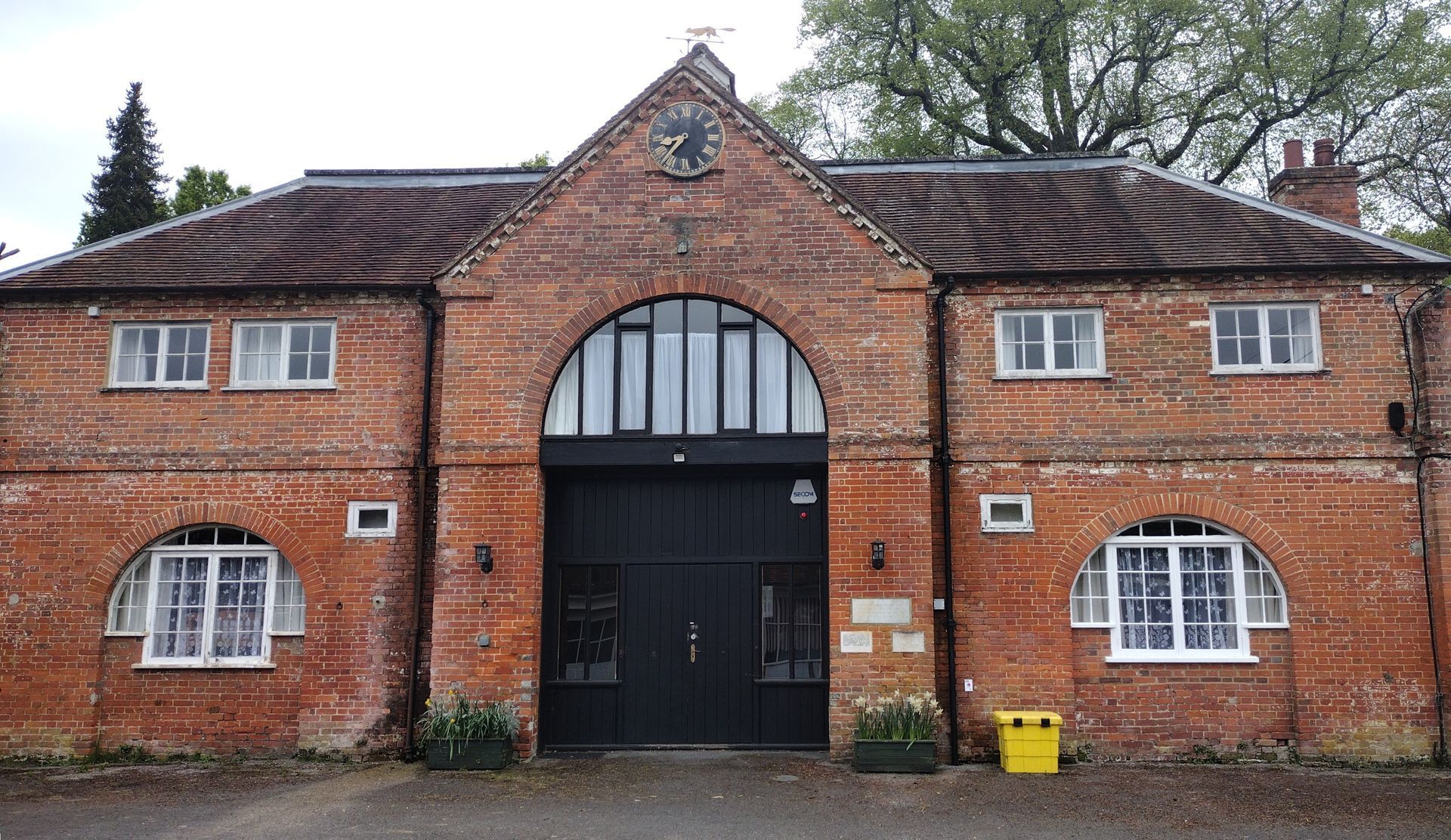 Image of a one story coach house style building with modern accommodation attached.