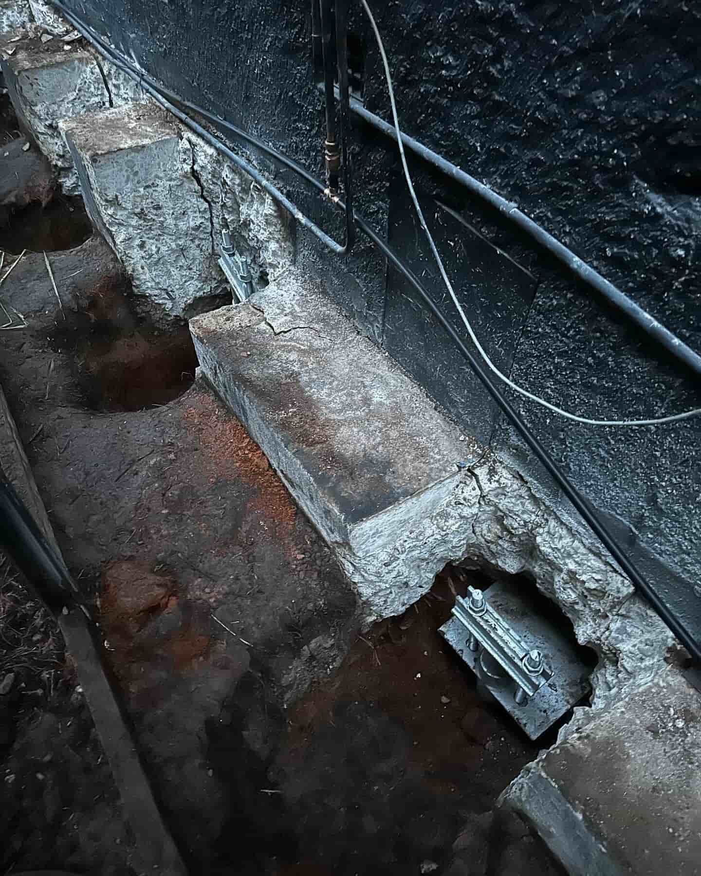 A house being underpinned with large holes around it — Affordable Underpinning Solutions In Shell Cove, NSW