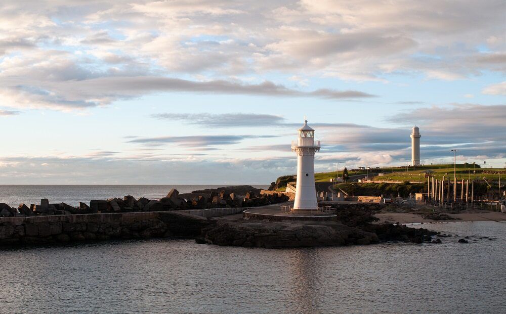 A Lighthouse Is Sitting On Top Of A Small Island — Affordable Underpinning Solutions In Wollongong, NSW
