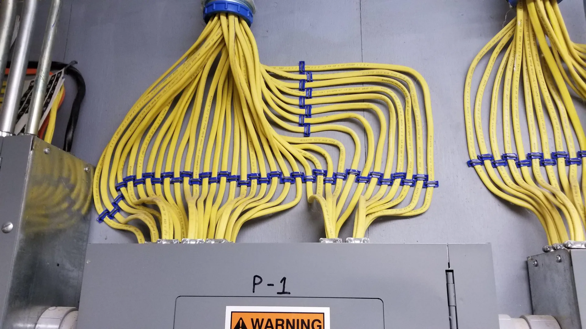 A bunch of wires are connected to a warning sign