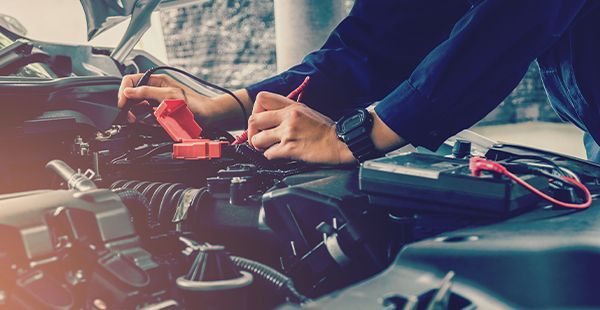 Up close of staff working on electrical system of a vehicle | Olmsted Auto Care
