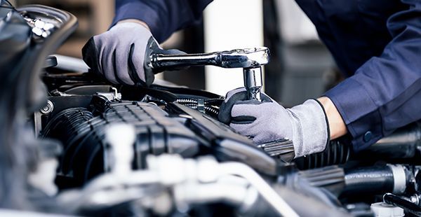 Staff member performing maintenance on vehicle | Olmsted Auto Care