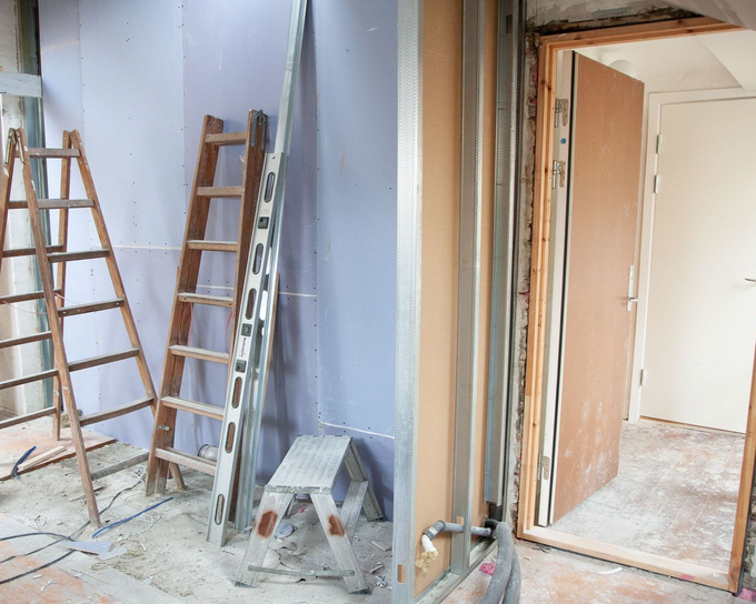 AA SmartWired Partially renovated room with ladders, tools, exposed walls, and construction debris