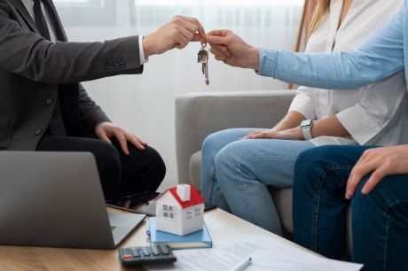 Mujer con sombrero y los brazos levantados, de pie al aire libre, fondo de bosque.