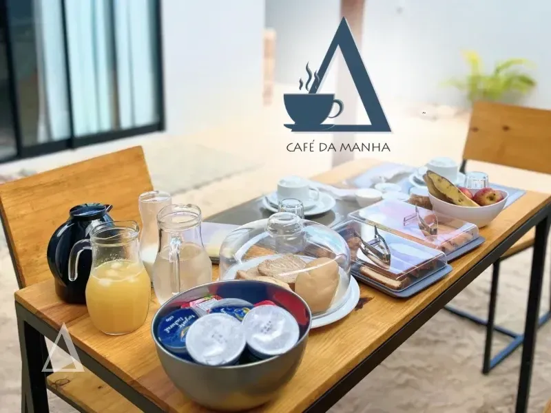 Mesa de café da manhã completa servida na varanda privativa da Quattuor Cabanas, com sucos, pães e frutas, destacando o conforto em São Miguel do Gostoso.