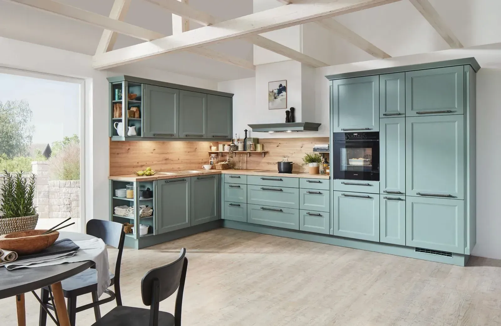 A kitchen with blue cabinets , a table and chairs.