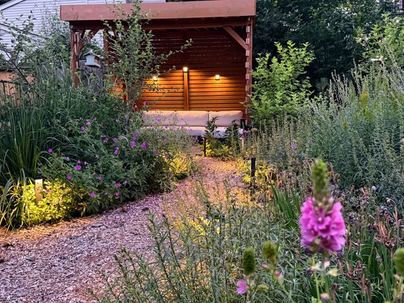 native plant habitat garden with bark chip pathway and green roof shade structure 