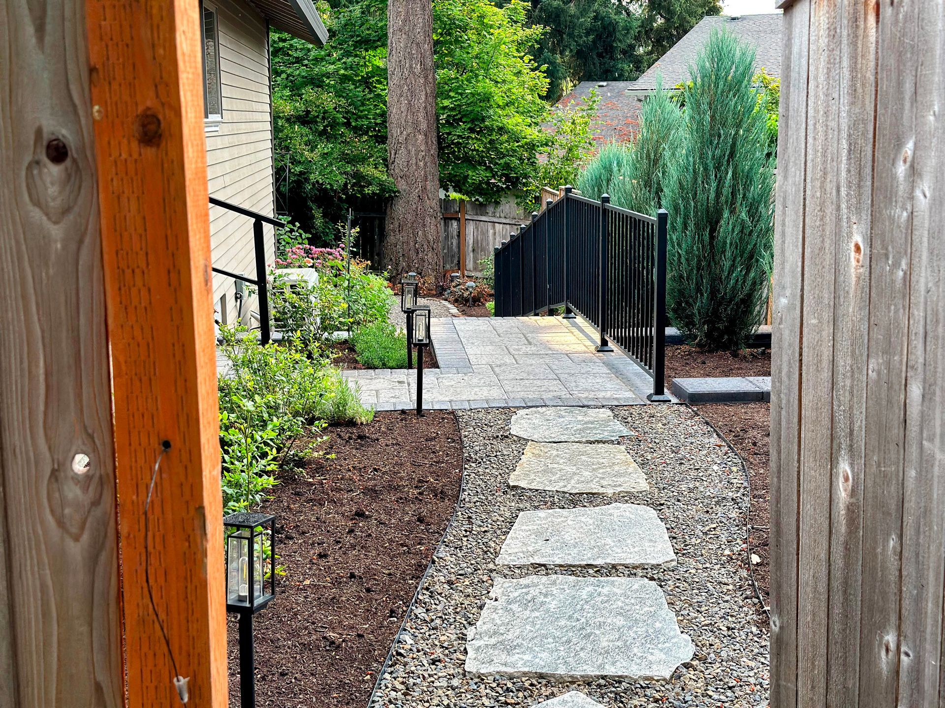 safe stairway gravel flagstone pathway with narrow privacy screening trees