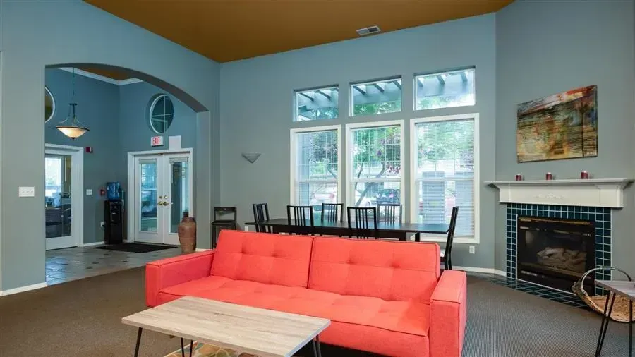 Living room with red sofa, fireplace, and dining table, with blue walls and gold ceiling.