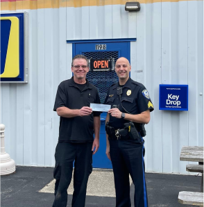Two men standing in front of a store with a sign that says open | East Cooper Auto Pros