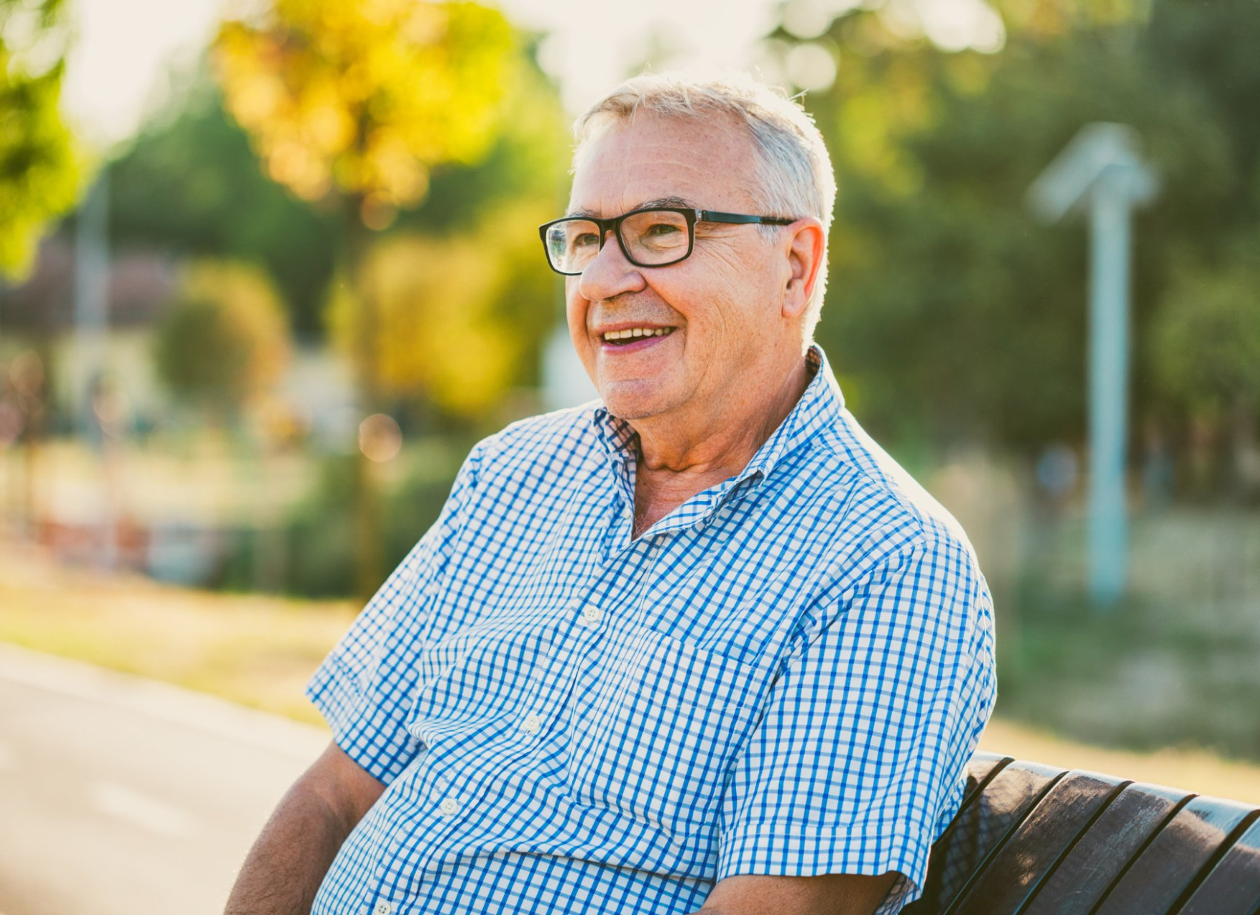 elderly man sitting on bench outdoors