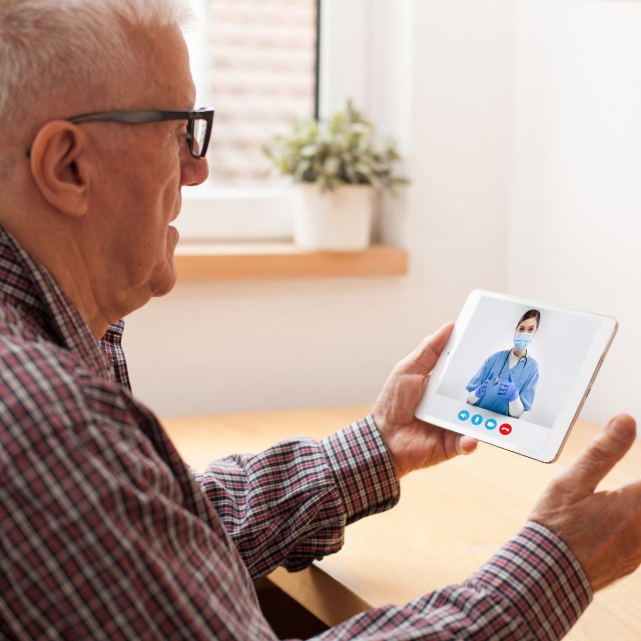 elderly caucasian man talking to doctor via telehealth video call