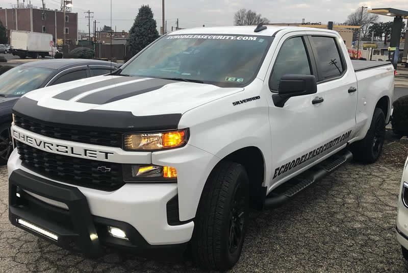 White Chevy Silverado pickup truck with black accents, parked outdoors.