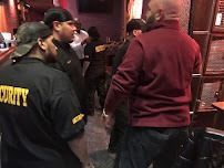 Security staff at a venue, wearing black shirts with