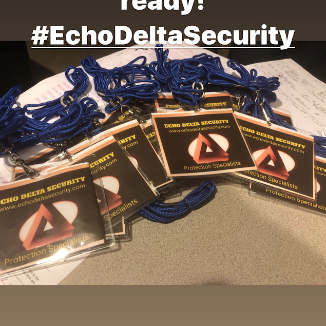 Pile of Echo Delta Security badges with blue lanyards; brown background.