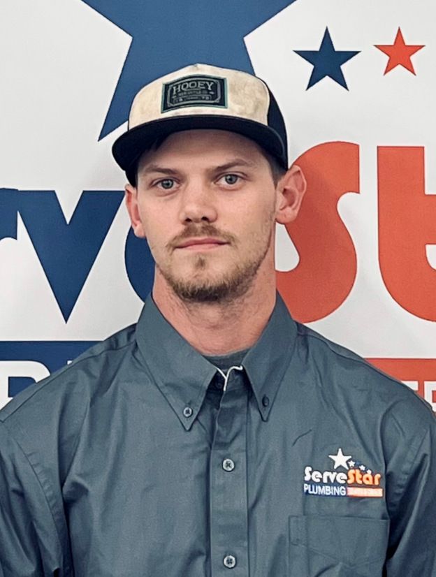 A man wearing a hat and a shirt that says servestar plumbing