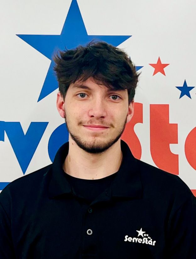 A man wearing a black shirt with the word servstar on it