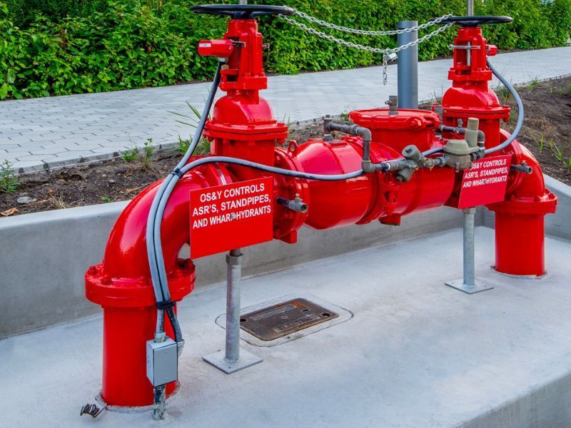 A red fire hydrant is sitting on a sidewalk next to a sidewalk.