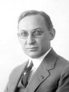 A black and white photo of a man in a suit and tie.