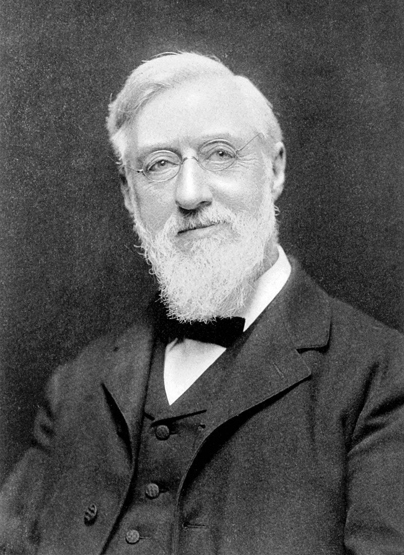 A man with a beard and glasses is wearing a suit and bow tie.