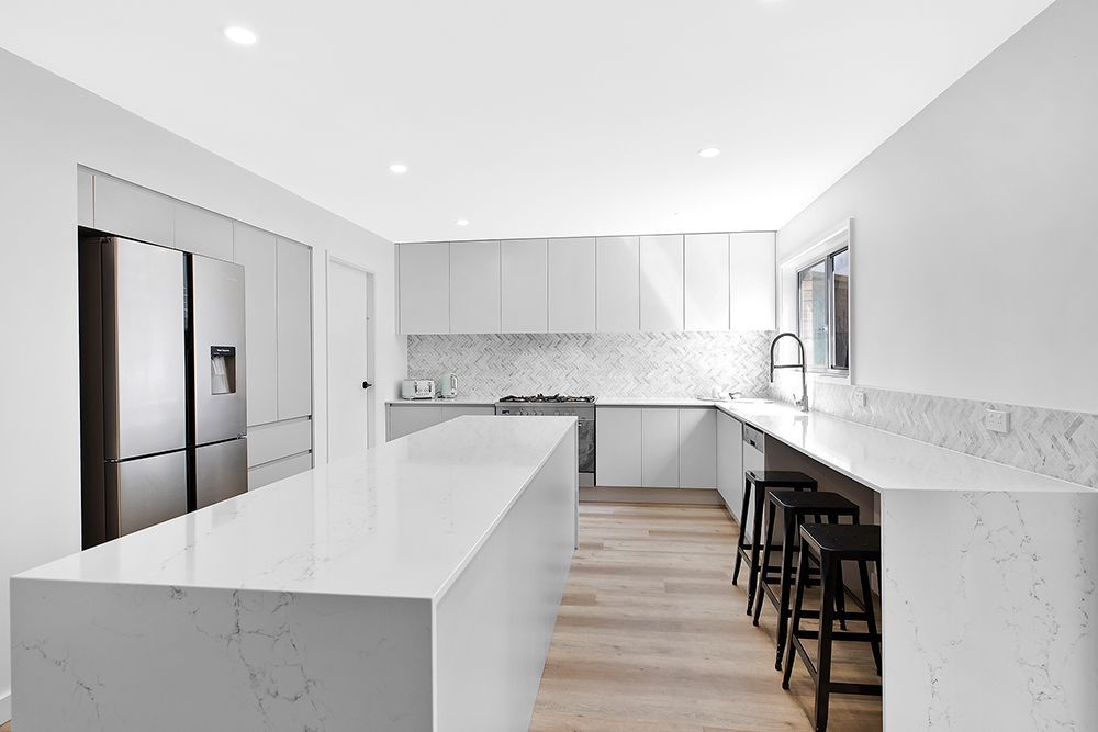 Modern, All-white Kitchen With a Large Island, Countertops — Affordable Tiles and Pavers In Morisset, NSW