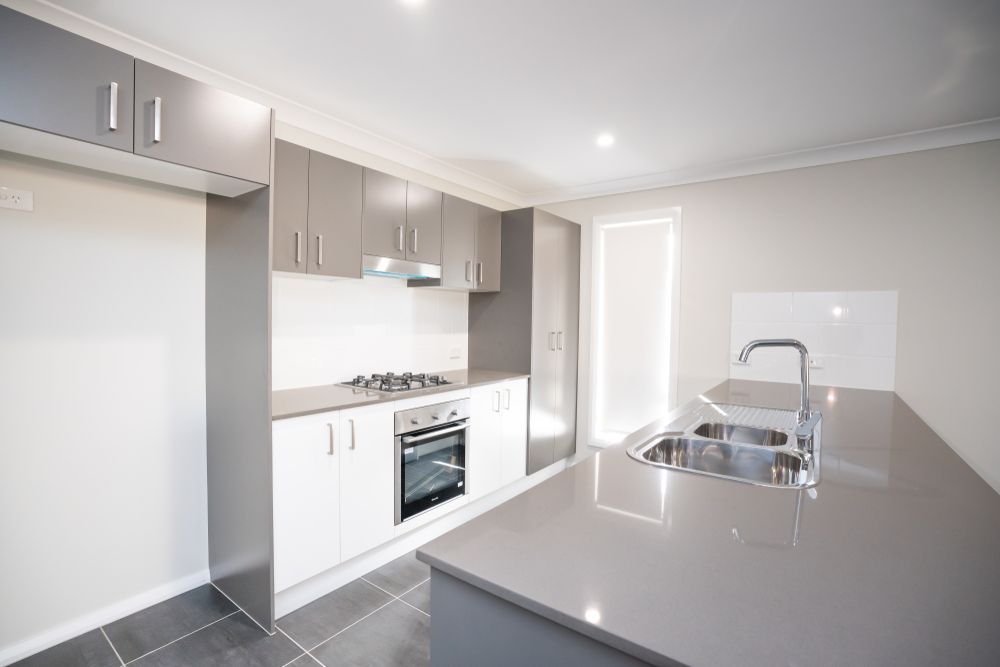 Modern Kitchen With Grey and White Cabinets, Stainless Steel Appliances — Affordable Tiles and Pavers In Morisset, NSW