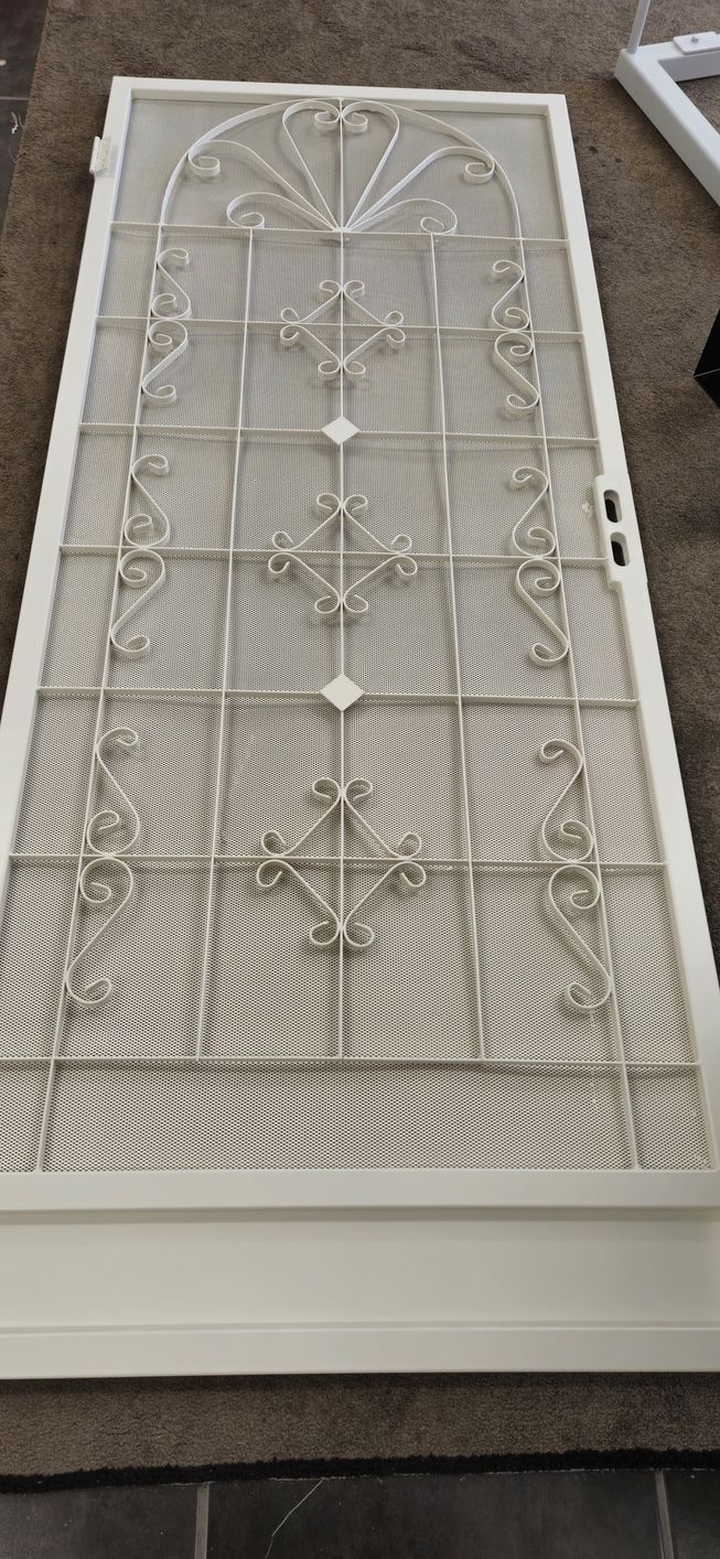 A white door with a screen on it is sitting on a carpet.
