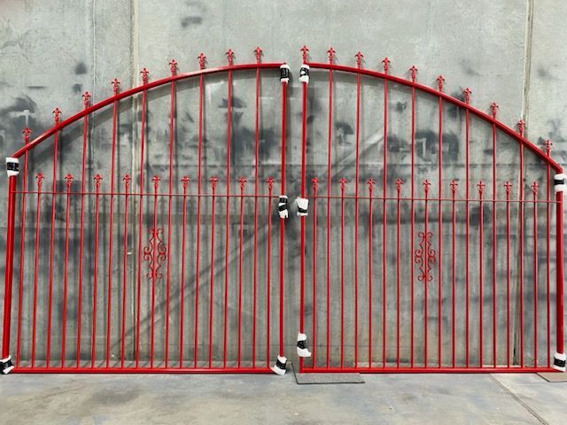 A red gate is sitting in front of a concrete wall