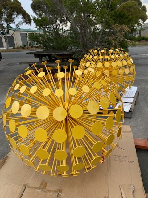 Two yellow dandelions are sitting on top of a cardboard box