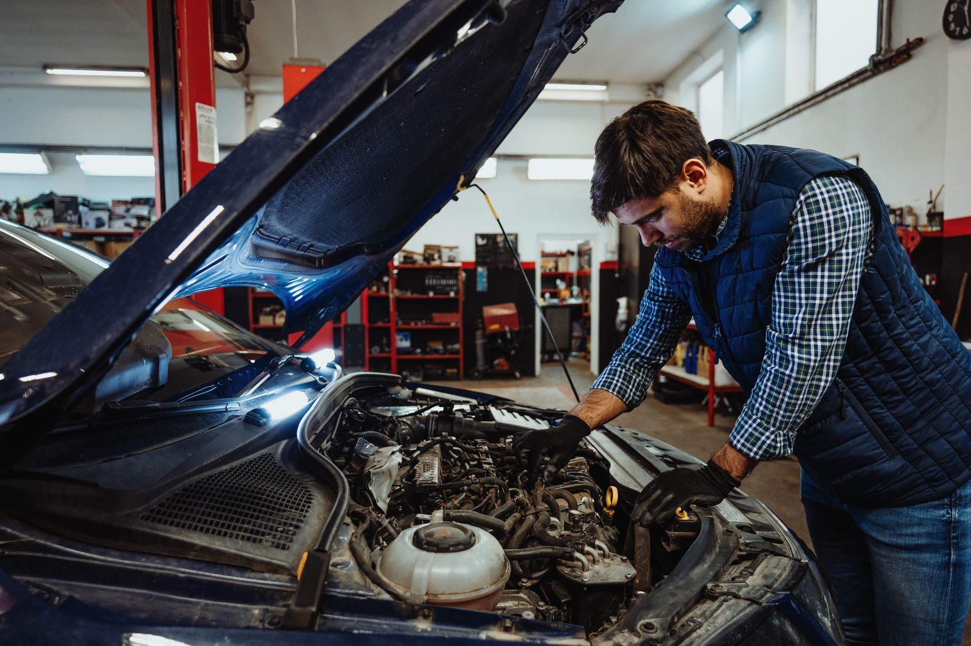 A car mechanic fixing a car in a car repair shop.