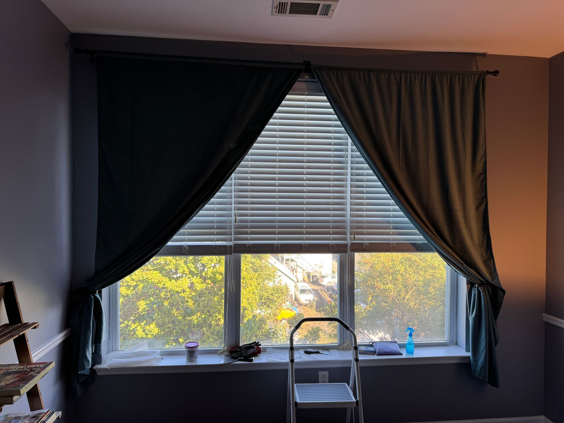 Beige curtains hang in front of a window, a/c unit below, white walls and ceiling, installation done in stamford connecticut
